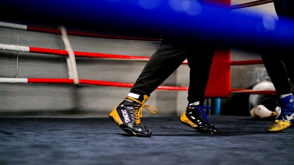 Close-up of two boxers' feet and footwear in a ring